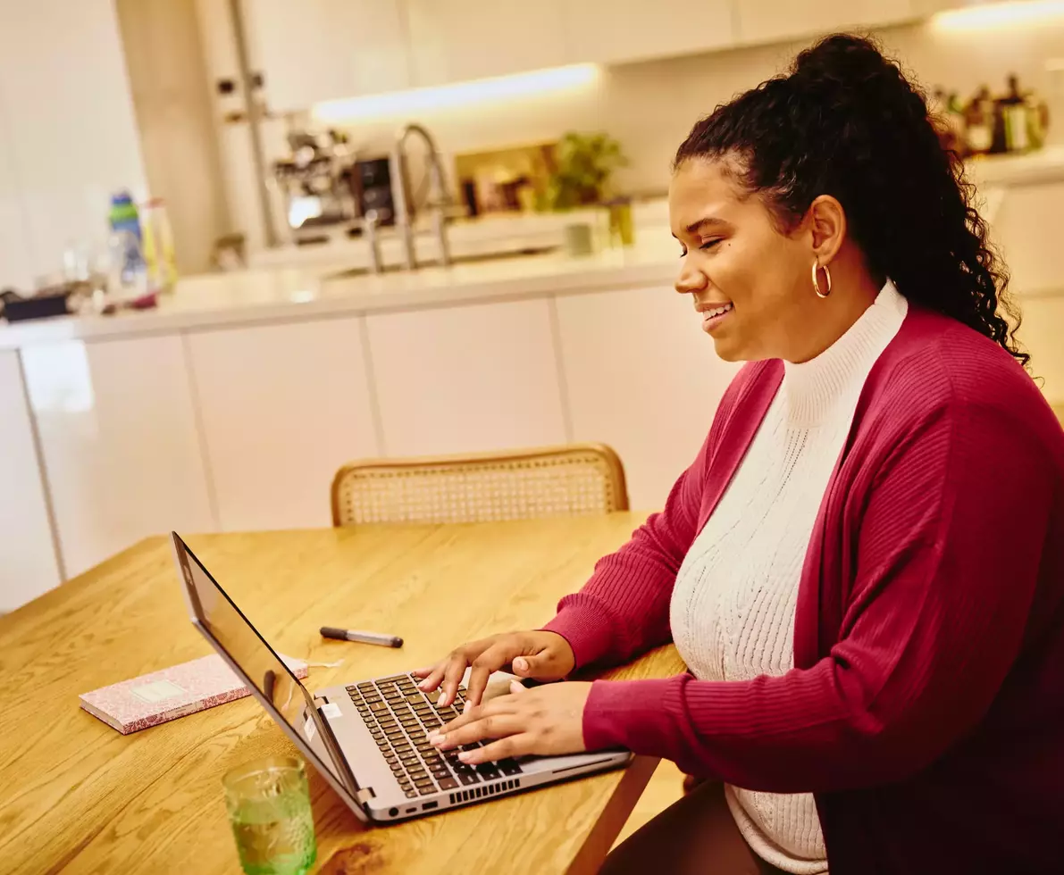 femme souriante au travail à l'aide d'un ordinateur portable